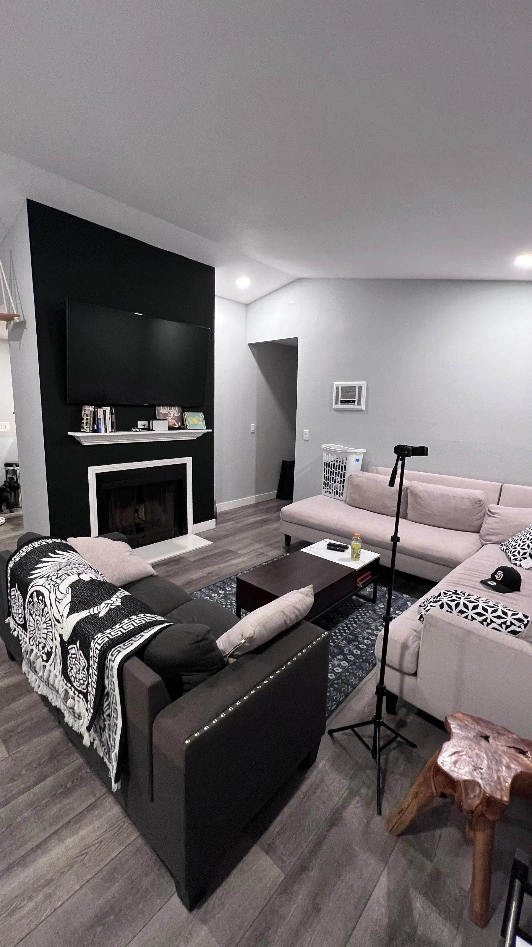 Living room with new flooring and a black fireplace accent wall