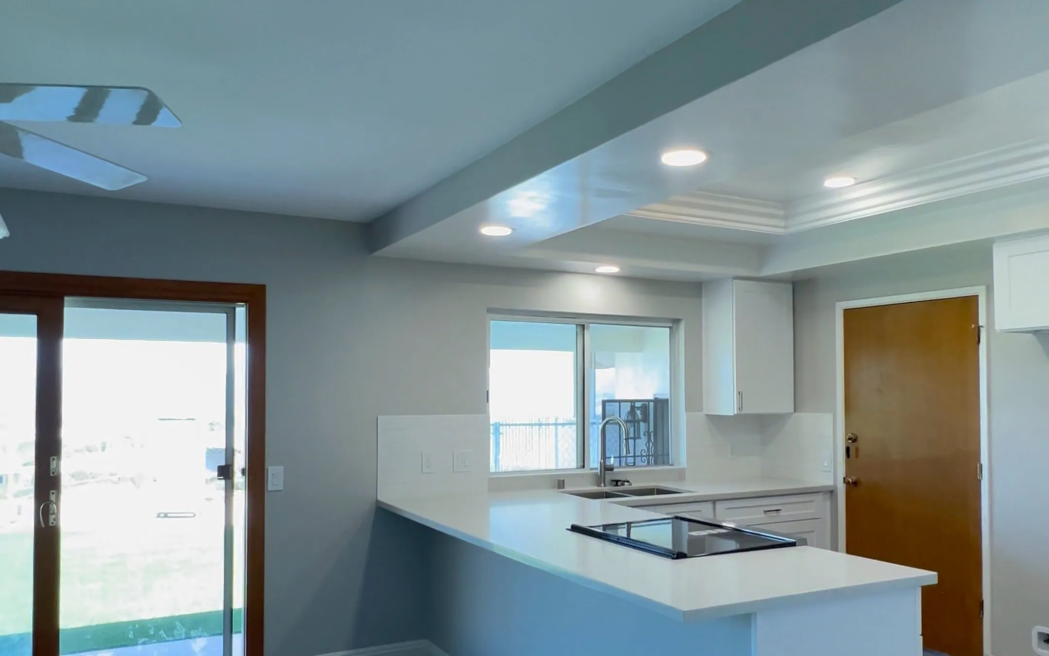 NewGen open-plan kitchen remodel with quartz peninsula, tray ceiling and new plank flooring